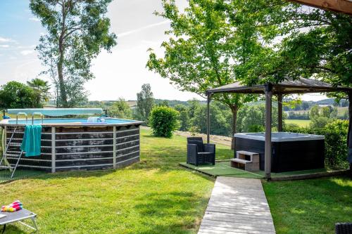 a backyard with a hot tub and a gazebo at Chalet Mélèze - Les Chalets de Barruérot - Spa jacuzzi privatif - Piscine en été in Peyrusse-Grande