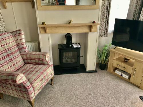 a living room with a fireplace and a stove at Debran Lodge in Angus