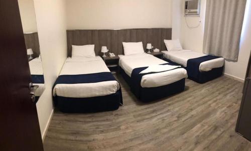 a hotel room with two beds in a room at Hayat Al madinah Hotel فندق حياة المدينة in Al Madinah