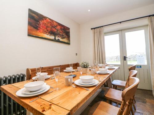 a dining room with a large wooden table with chairs at Burrs Farm in Buxton