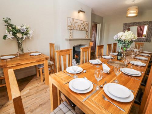 a dining room with a wooden table and a fireplace at Burrs Farm in Buxton
