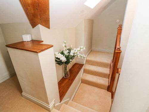 a stairway with a vase of flowers in a room at Burrs Farm in Buxton