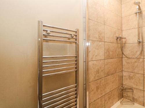 a shower with a glass door in a bathroom at Burrs Farm in Buxton