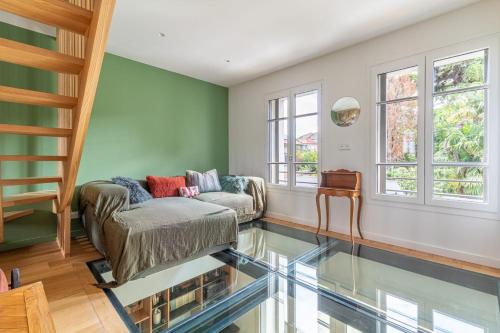 un salon avec des murs verts et un sol en verre dans l'établissement Spacious house with garden, à Toulouse