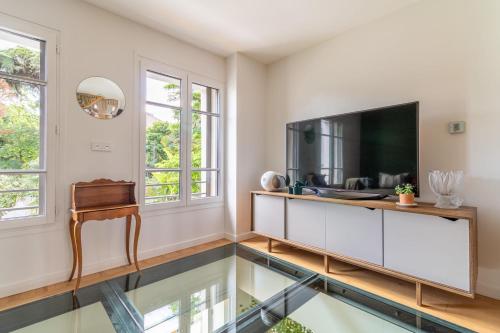- un salon avec une télévision et un sol en verre dans l'établissement Spacious house with garden, à Toulouse