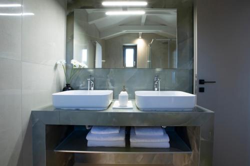 Ilania Luxury Villas في تسوكالادهيز: حمام به مغسلتين ومرآة كبيرة