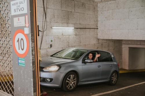 a woman driving a car in a parking lot at Boutiquehotel Stadthalle in Vienna