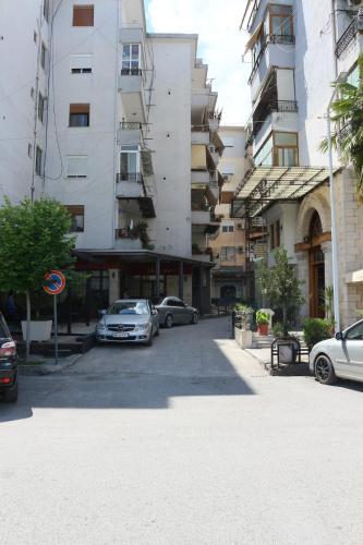 a parking lot with cars parked in front of buildings at Artemis Guesthouse in Gjirokastër
