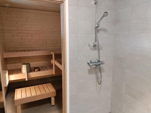 a shower in a bathroom with a shower at Maatilamatkailu Jänisvaara aittahuoneet in Kolinkylä