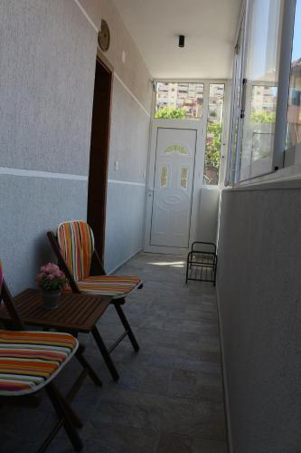 a hallway with chairs and a door and a table at Artemis Guesthouse in Gjirokastër