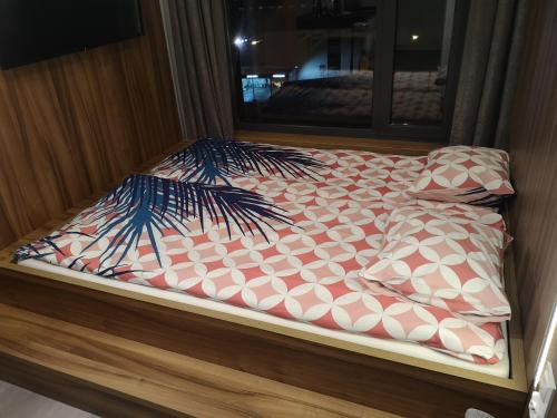 a bed with a comforter and pillows on it at Magnolia Loft Apartments in Wrocław