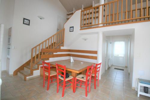 une salle à manger avec une table et des chaises rouges dans l'établissement Agréable maison, aperçu mer, wifi, à La Tranche-sur-Mer