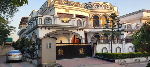 a house with a car parked in front of it at Butt Lodges 2 in Islamabad