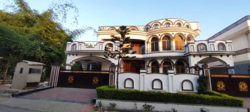 a large white house with a turret at Butt Lodges 2 in Islamabad