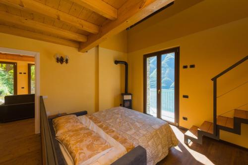 a bedroom with a bed and a large window at Tra Lago e Montagna Baita la Morena in Nesso