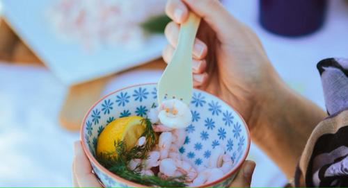 a person holding a cup of food with a spoon at Lofts du Presbytère in Matane