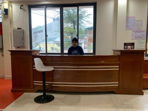 a person sitting at a counter in a courtroom at Khách Sạn Thành Trung Vàn Chảy in Quang Ninh