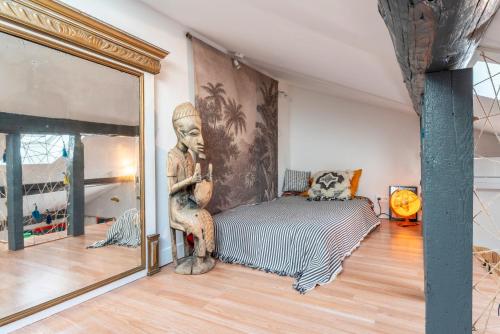 une chambre avec une statue devant un miroir dans l'établissement En plein centre d'Avignon, à Avignon