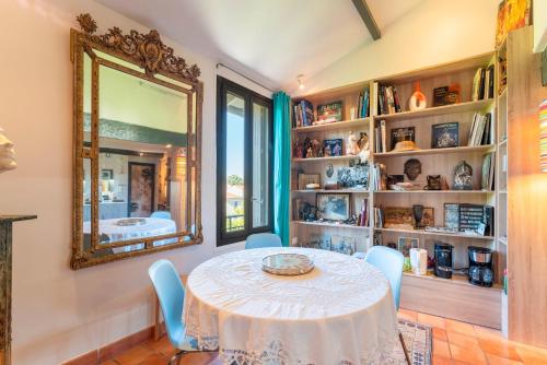 une salle à manger avec une table et un miroir dans l'établissement En plein centre d'Avignon, à Avignon