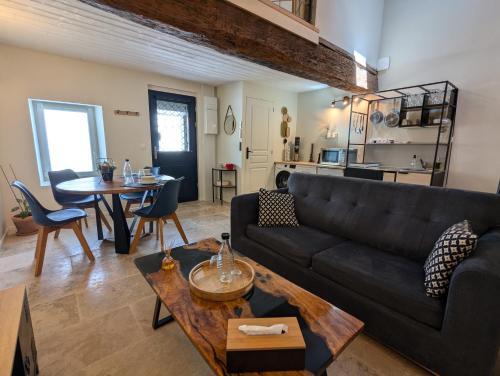 a living room with a black couch and a table at Les Pierres Douces in Champniers
