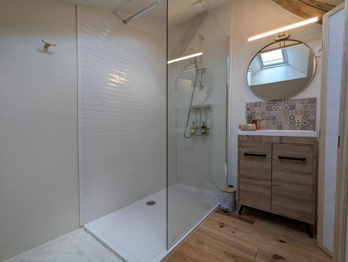 a bathroom with a shower with a sink and a mirror at Les Pierres Douces in Champniers