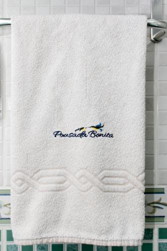 a towel on a towel rack with a logo on it at Hotel Pousada Bonita - 150m Metrô Paraiso e 1Km do inicio Av Paulista in São Paulo
