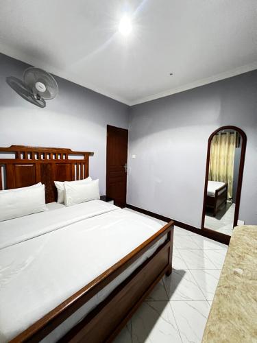 a bedroom with a large bed and a mirror at Hadraj Moshono Apartment2 in Arusha