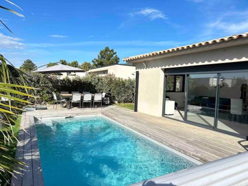une piscine avec une terrasse en bois à côté d'une maison dans l'établissement Corsica Suttana Vacanze, à Lecci