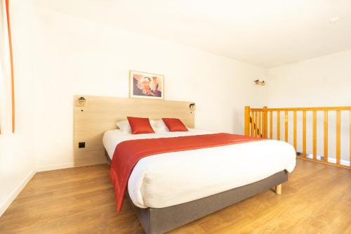a bedroom with a large bed with red pillows at City Résidence Bordeaux Centre in Bordeaux