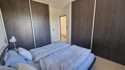 - une chambre avec 2 lits et des murs en bois dans l'établissement Détente, à Magalas