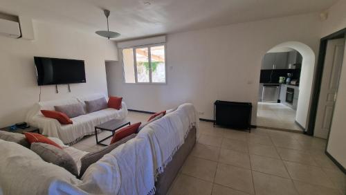 un salon avec deux canapés et une télévision dans l'établissement Détente, à Magalas