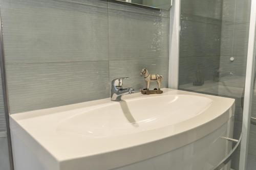 un lavabo con un grifo encima en Sirio - bilocale comodo a 200 m dal mare e con piscina sul tetto, en Borghetto Santo Spirito