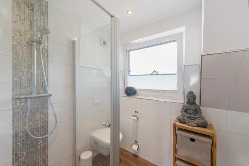 a bathroom with a shower and a toilet and a window at Villa Seebrise in Göhren-Lebbin