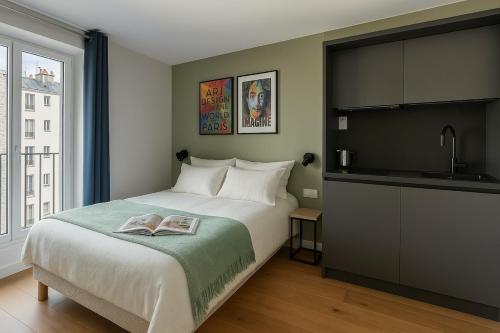 - une chambre avec un lit et un livre dans l'établissement Paris Studio with view of Montmartre, à Paris
