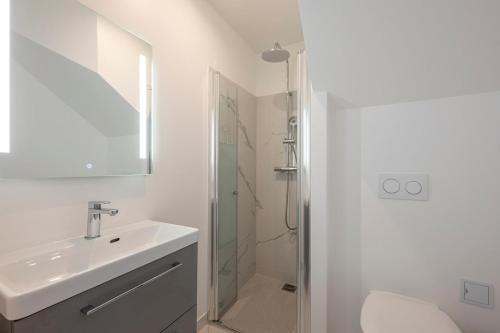 une salle de bain blanche avec un lavabo et une douche dans l'établissement Paris Studio with view of Montmartre, à Paris