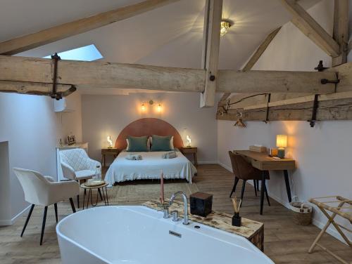 a bedroom with a bed and a tub in a room at Les Pierres Douces in Champniers
