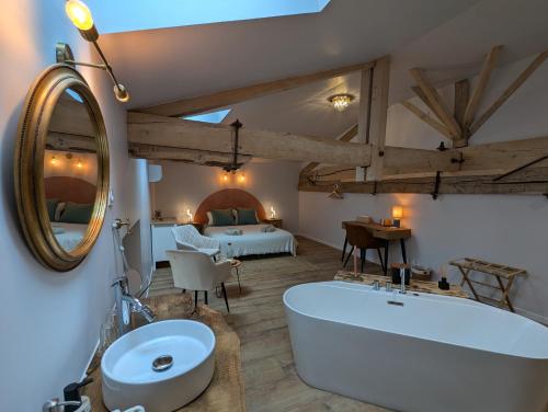 a bathroom with a tub and a bedroom with a bed at Les Pierres Douces in Champniers