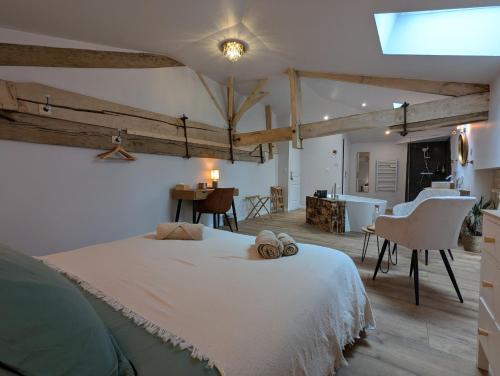 a bedroom with a large white bed with two towels on it at Les Pierres Douces in Champniers