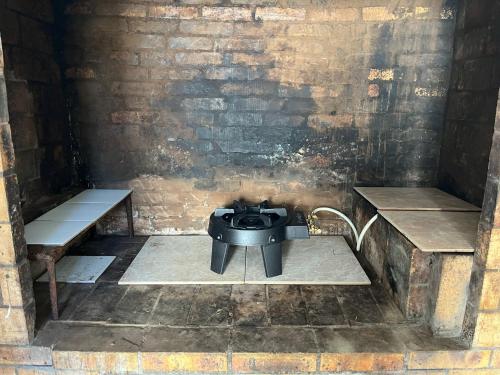 a room with a stove and two benches at Studio Au Coeur de Grand Ilet - Chez Tania! in Salazie