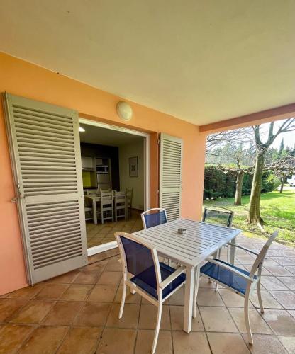 Une table à manger et des chaises sont disponibles sur la terrasse. dans l'établissement Les Palmiers Appartement, à Grimaud