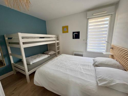 ポルニシェにあるCharmant T2 direct plageの二段ベッド2台と窓のある寝室