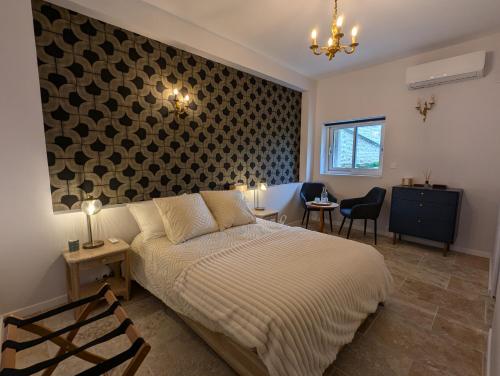 a bedroom with a bed and chairs and a wall at Les Pierres Douces in Champniers