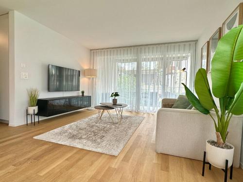 a living room with a couch and a table at Seeland Bijou Apartment - 2 bedrooms in Kerzers
