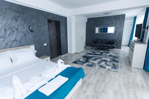 a bedroom with a bed and a couch in it at RUXO Hotel in Mamaia Nord
