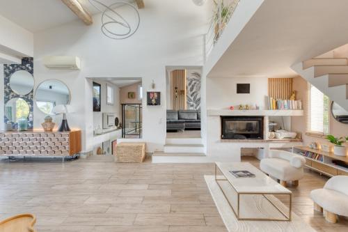 Elle comprend un salon doté de murs blancs et d'une cheminée. dans l'établissement Villa à louer, 6 pièces - Saint-Raphaël 83700, à Saint-Raphaël