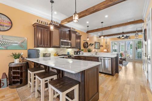 a kitchen with wooden cabinets and a large white counter top at Outriggers 18- Happy Daze in New Smyrna Beach
