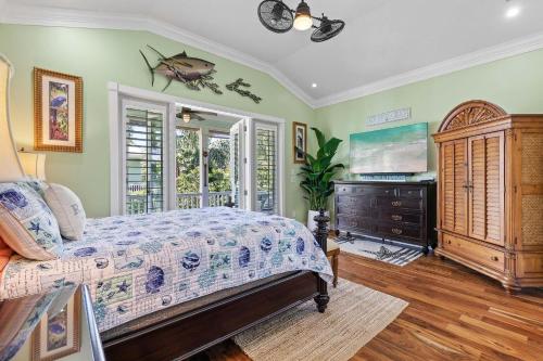 a bedroom with a bed and a dresser and a tv at Outriggers 18- Happy Daze in New Smyrna Beach