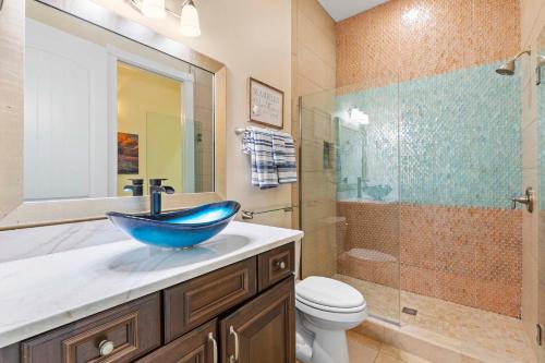 a bathroom with a blue bowl sink and a shower at Outriggers 18- Happy Daze in New Smyrna Beach