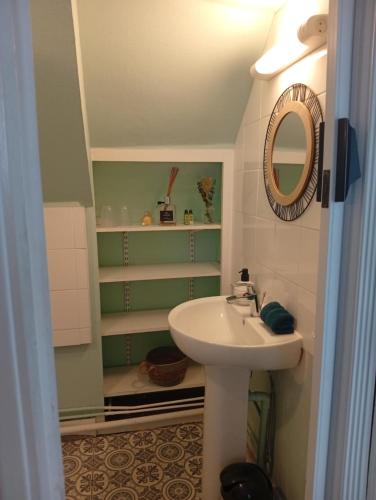 une salle de bain avec un lavabo et un miroir dans l'établissement La Cabane du Pêcheur, à Dieppe