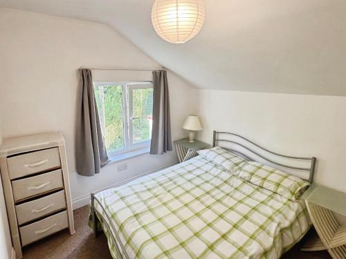 Thistle Cottage في Wootton Bridge: غرفة نوم بها سرير ونافذة